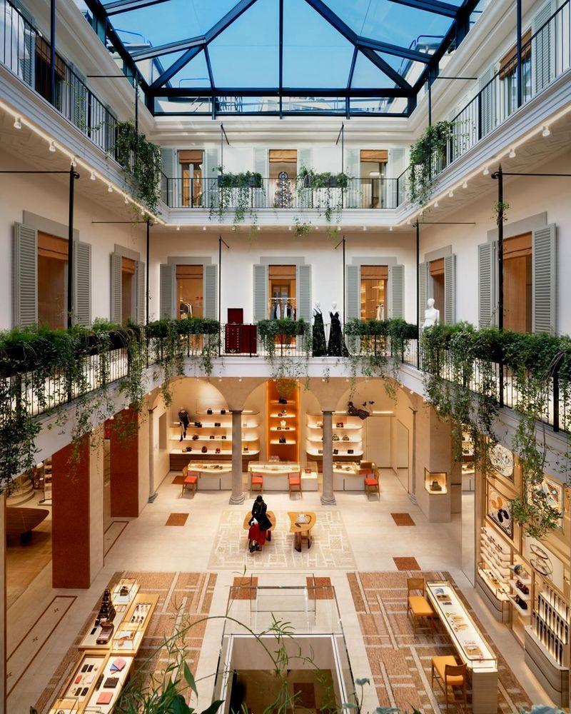 Ambiente interno da loja Louis Vuitton com exposição de produtos e entrada de luz natural.