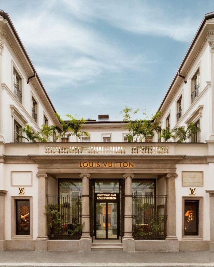 Fachada clássica da loja Louis Vuitton em Milão, com letreiro em destaque e janelas grandes mostrando o interior.