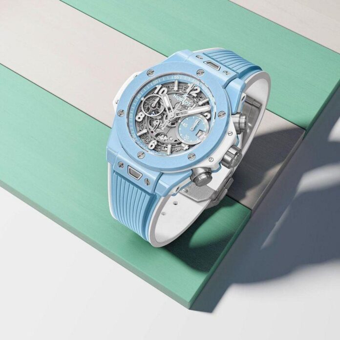 Relógio Hublot Big Bang Unico em uma superfície de madeira listrada verde e azul claro.