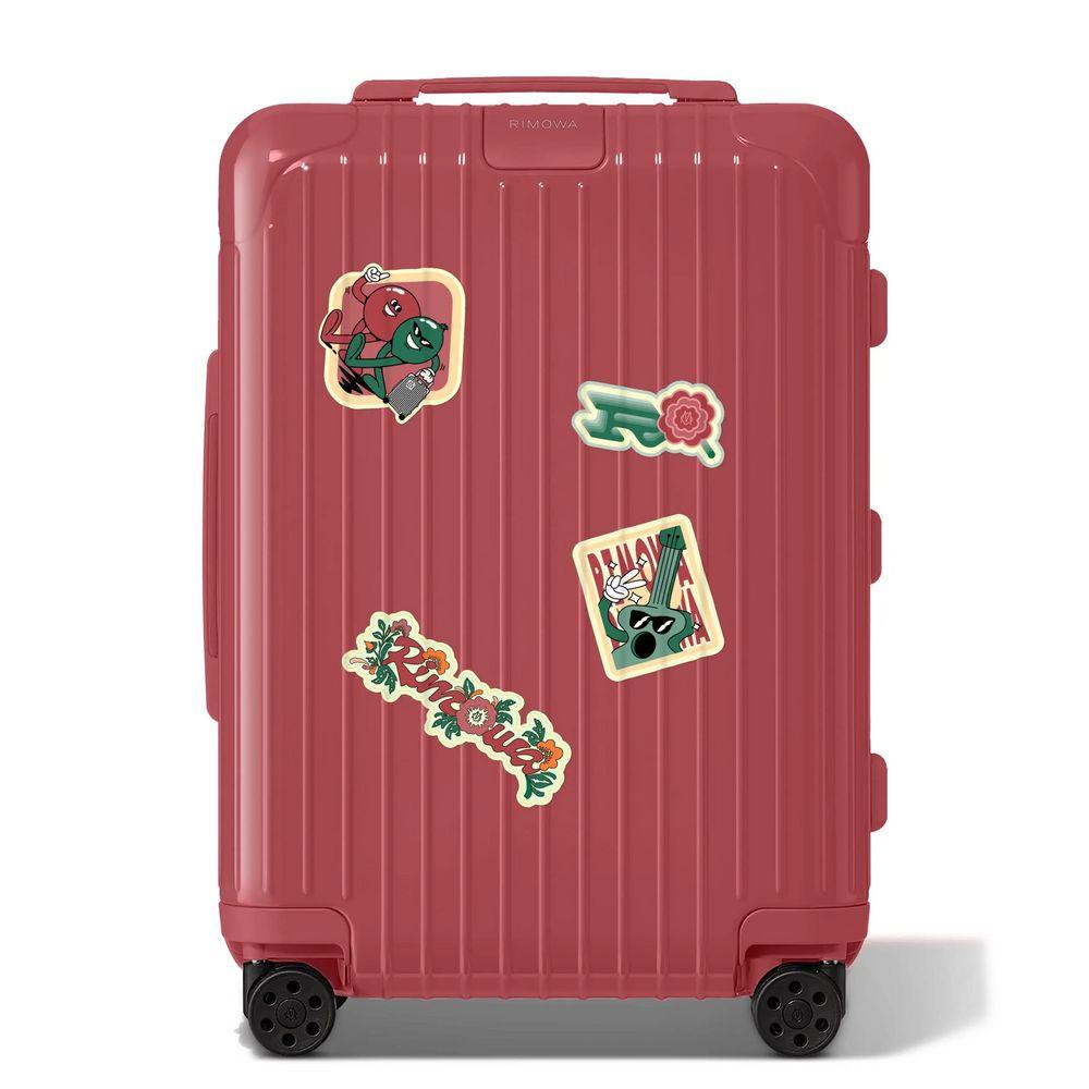Adesivos coloridos sobre uma mala RIMOWA, representando o estilo e a personalização.