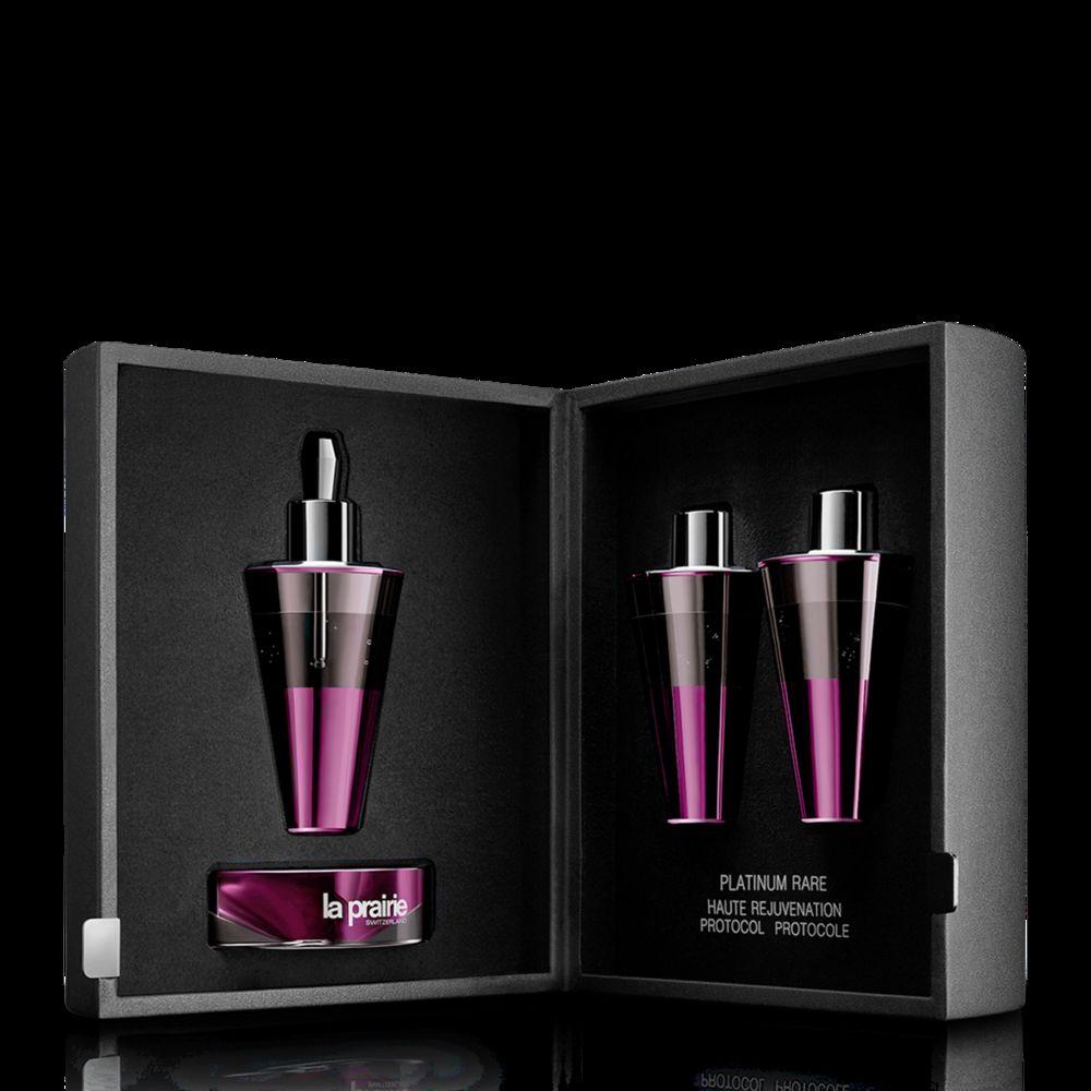Caixa preta com fecho magnético com frascos de vidro e logotipo da La Prairie em fundo preto.