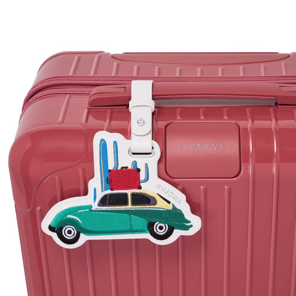 Charms decorativos em uma mala RIMOWA, adicionando um toque pessoal.