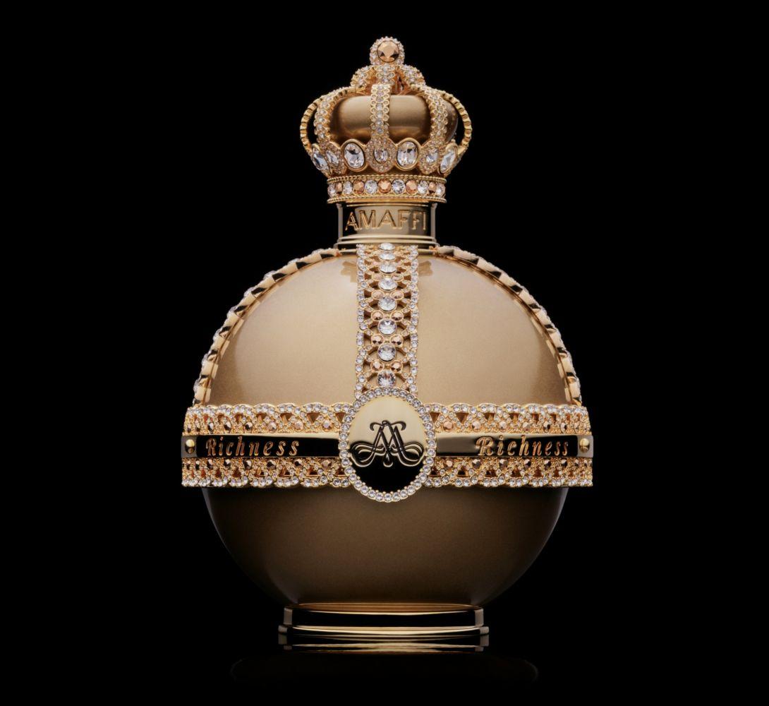 Frasco de perfume dourado em destaque, adornado com uma coroa na tampa sobre um fundo preto liso.