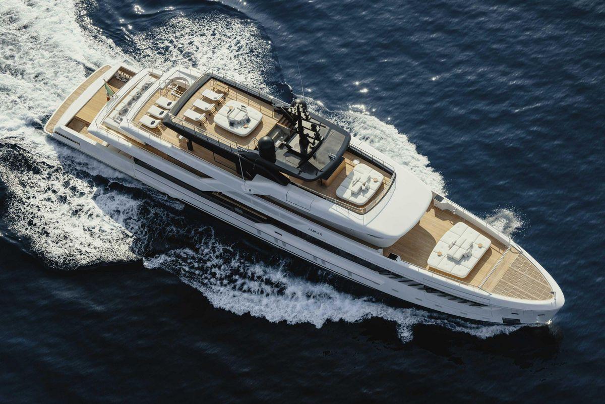 Iate luxuoso rodeado de água azul do oceano, com áreas de estar no deck superior e uma ampla janela vista para o mar.