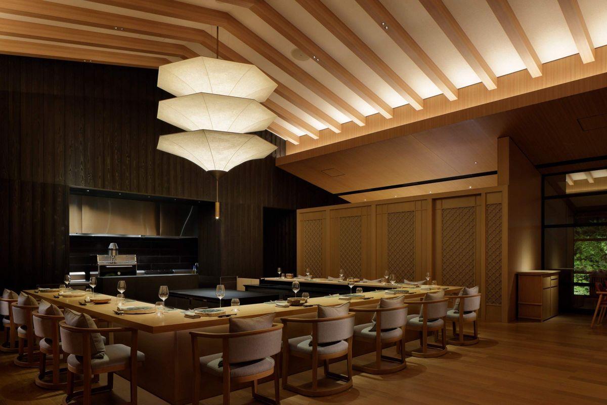 Mesa do chef no restaurante Tenjin do hotel Roku Kyoto, com um ambiente aconchegante e elegante.