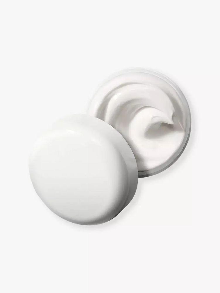 Recipiente redondo com creme branco em fundo branco simples.
